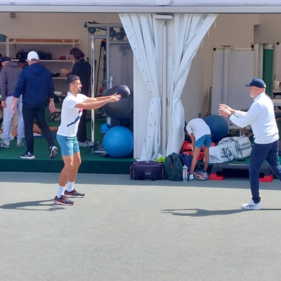 Novak se zagreva za meč – neočekivan susret FOTO