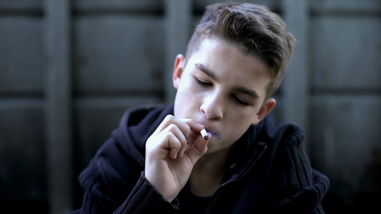 Мальчик подросток курит